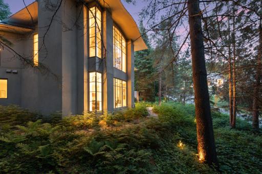 Situated on nearly an acre of land, this soft contemporary property presents a verdant sanctuary that instantly transports you to a secluded, wooded oasis, providing a sense of serenity and tranquility.