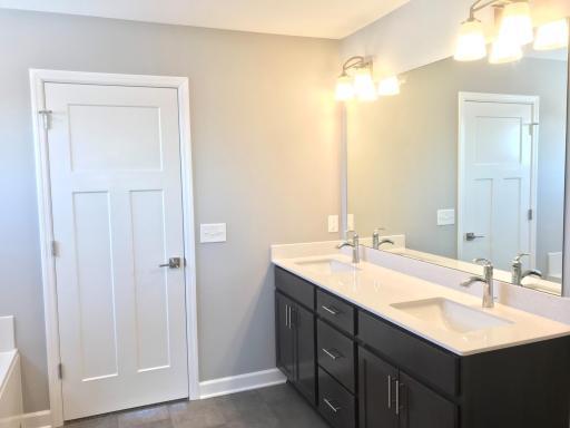 Primary bath with high end fixtures, dual vanity, three panel doors. Finishes will vary.