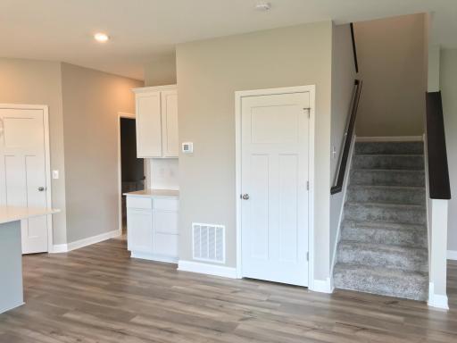 Corner kitchen pantry with plenty of room, durable vinyl plank flooring, and timeless white three panel doors.jpg