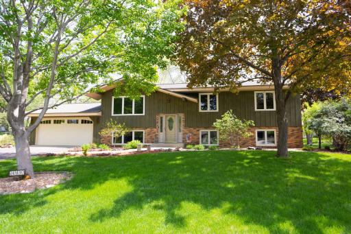 Beautiful split entry home w/ wood/brick siding and unique roof peak over the living room windows