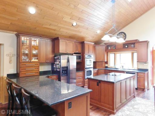 Gorgeous kitchen with granite counter tops, double oven and cooktop stove.
