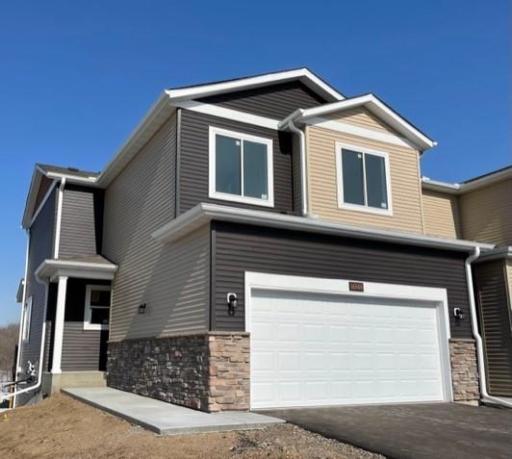 Home features stone accents with a covered front entry and backs up to the North Commons Parkland.