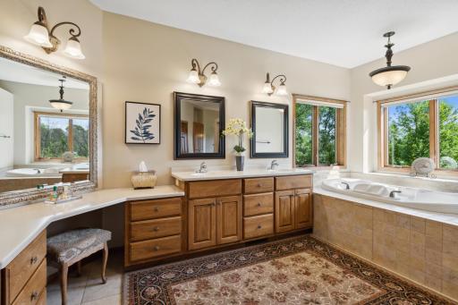 The primary ensuite bath has a large vanity with cabinets and sit down area. Like a luxurious day at the spa!