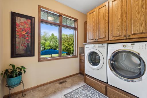 The large laundry room has ceramic tile flooring, a utility sink, a new LG front load HE washer and Electrolux front load gas dryer. Not to mention the custom built pedestals and cabinets!