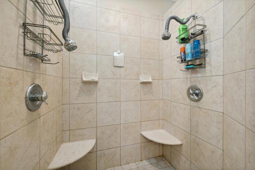 The large, ceramic tiled walk-in shower has not one but TWO shower heads, TWO shelves, and TWO soap holders.