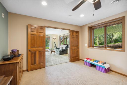 The bedroom/exercise room has a ceiling fan, recessed lights and an added luxe feel with the French doors.