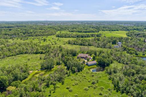 From here, you can see another house, but look how far away it is! Just beyond is all nearby Blaine has to offer, and in the background you can see downtown Minneapolis. It is stunning to know you can have privacy like this so close to everything!