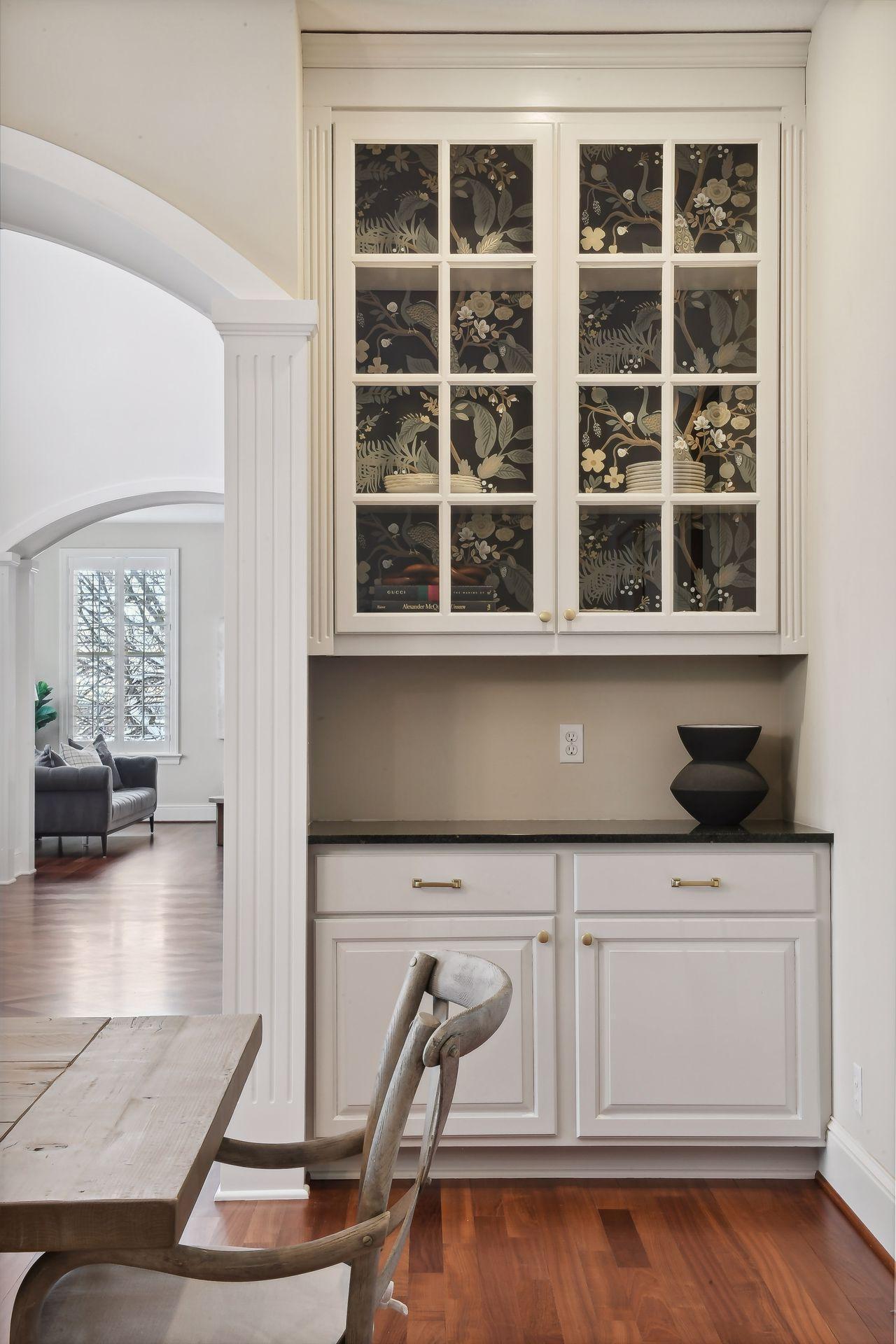 Designer wallpaper enhances the freshly enameled built-ins.