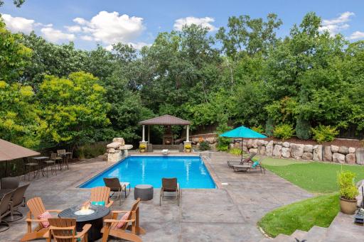Perfectly manicured grounds include a pool with waterfall feature, pergola, stone fireplace, putting green and professional landscaping.