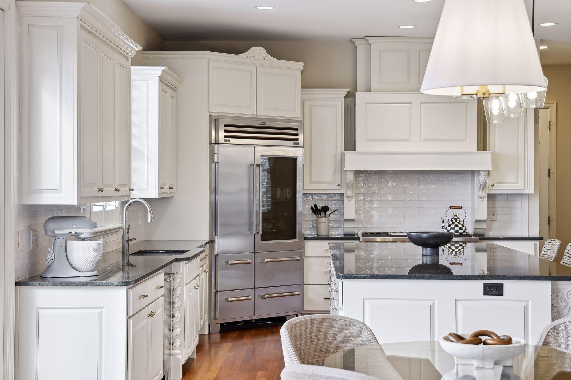 The gourmet kitchen features custom cabinets, intricate architectural details, and high-end appliances.