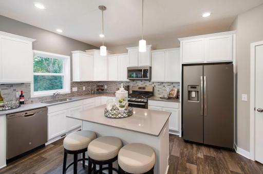 Photo from similar home. This home also has white cabinets and glass backsplash. Cabinet, center island and pantry storage. Note the tiered cabinets.