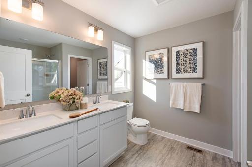 The owner's bath features a large shower and vanity with quartz top and 2 undermount sinks.
Photo from a similar home.
