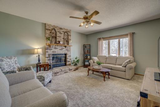 Bright and spacious main level living room with a cozy woodburning fireplace