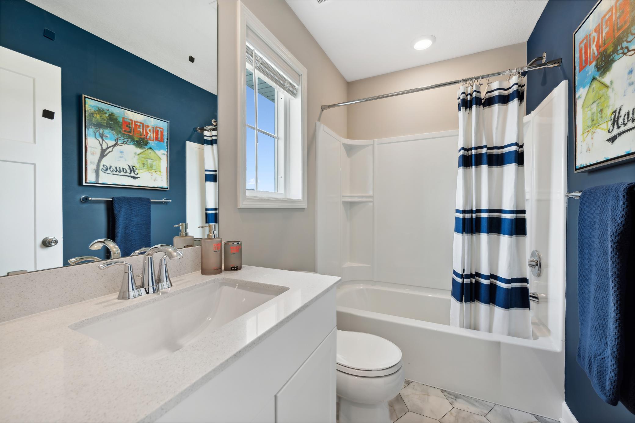 The hall bath features a tub/shower combination. *Please note, photos are of a model and are not the actual home, but very similar.