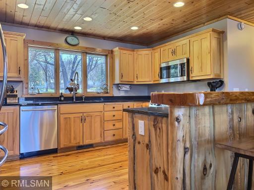 The kitchen area blends together beautifully with the sleek black granite counter tops, maple cabinets and live edge wood top on the island.
