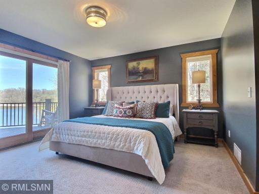 The main level bedroom is like a private oasis. The king size bed with the elegant, tufted headboard and quality bedding shout "jump in and sleep well" Get lake views from the moment you awake and slip right out to the deck for morning coffee!