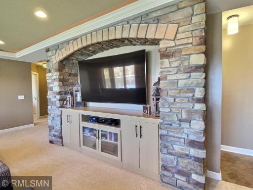 The focal point of the family room is the built in maple cabinets and arched, brick accents. Movie night will be a big hit with the huge flat screen television.