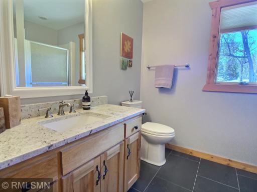 This 3/4 bathroom is conveniently located near the garage entrance. More beautiful granite and natural stone floor.