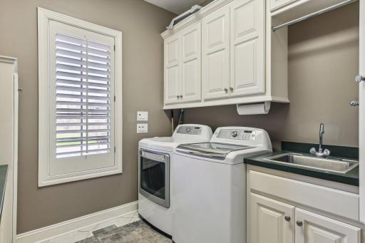 Generous main level laundry room with loads of built-ins