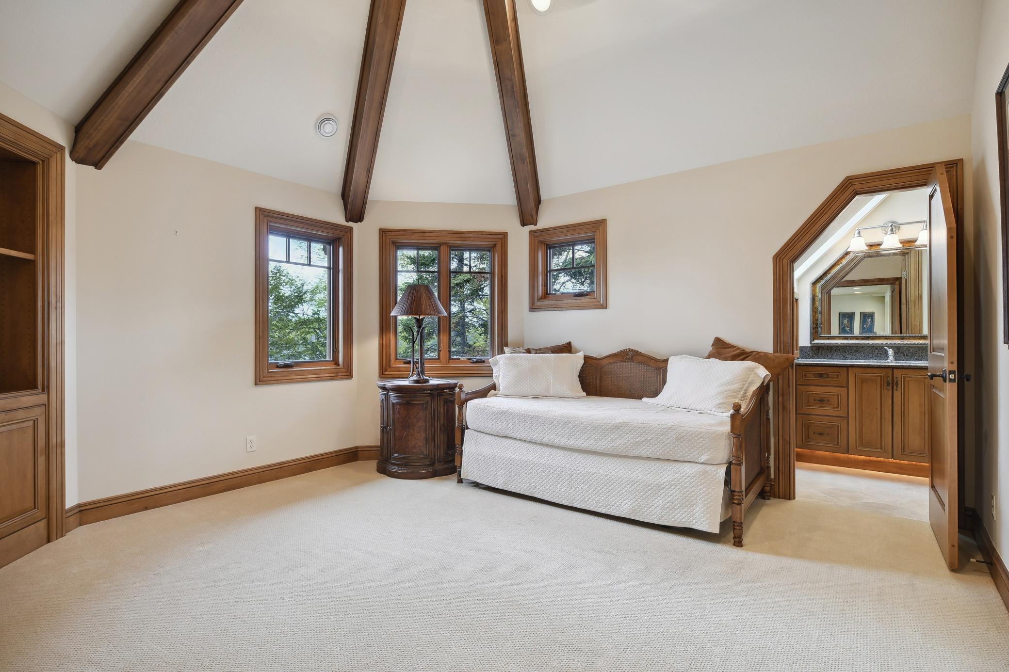 Bedroom 4 features a vaulted ceiling with beams and an en suite private bath.
