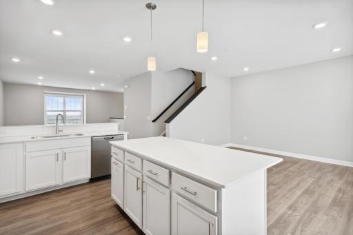 Large kitchen with additional space which could be used for a family room or dining area. Photos not of actual home. Actual home will be similar floorplan; some colors and features may vary.