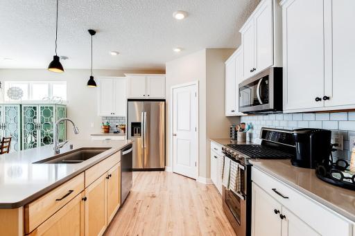 Open and inviting. Spacious corner pantry for all your kitchen appliances with abundant room for cooking and hosting! Staged model photos. See listing agent for home specific selections.