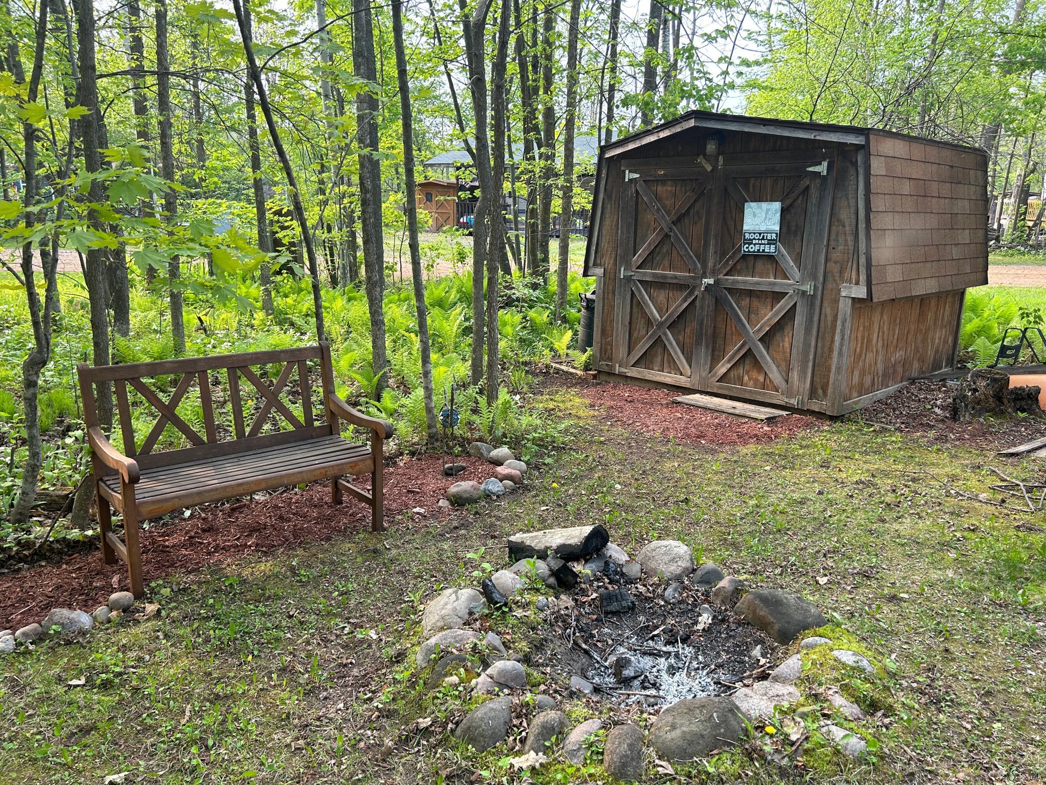 Bench to rest on while sitting around firepit and view of shed...