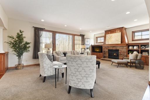 The Living Room showcases a gas fireplace with stone surround flanked by built-in cabinetry and transom windows above