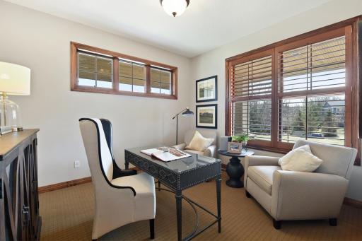 A comfortable home office/den is set through French doors off the foyer
