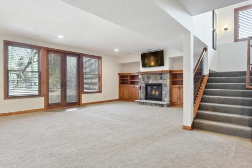 The family room features a gas fireplace flanked by built-in cabinetry and French doors to the backyard