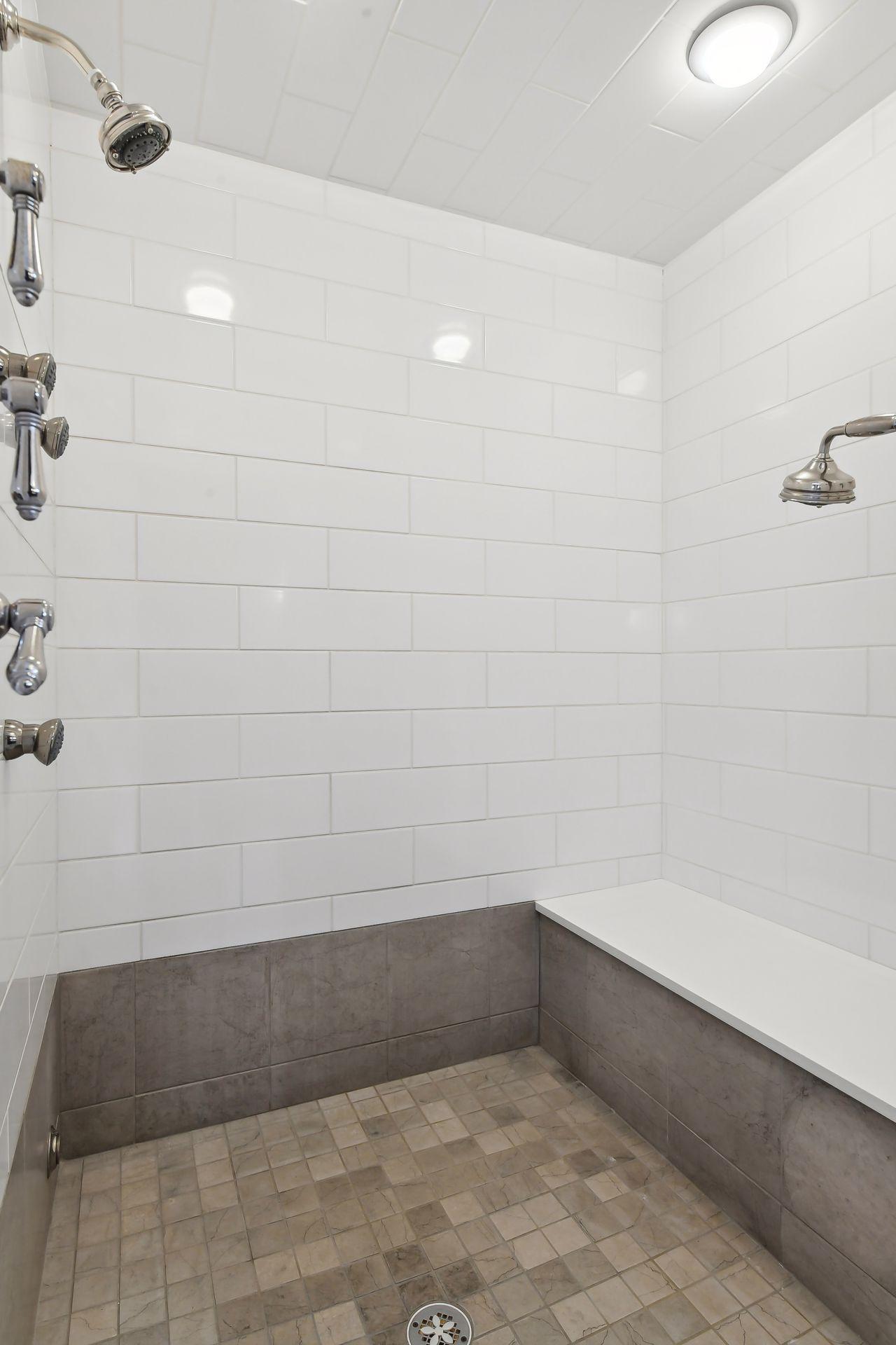 The large, walk-in steam shower features body jets, a built in bench and two shower heads.