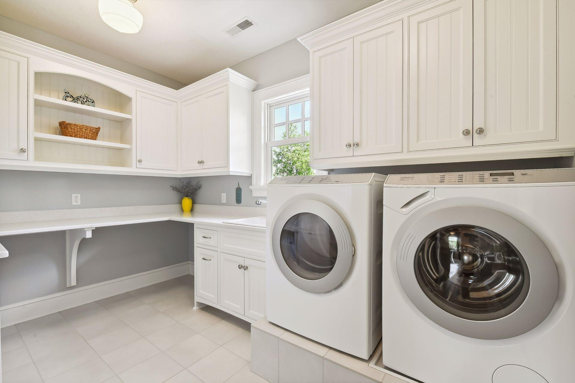 Located on the upper level is a large Laundry Room with front-load Miele washer and dryer, deep laundry sink, quartz countertops, clothes hanging rod and a built-in ironing board.