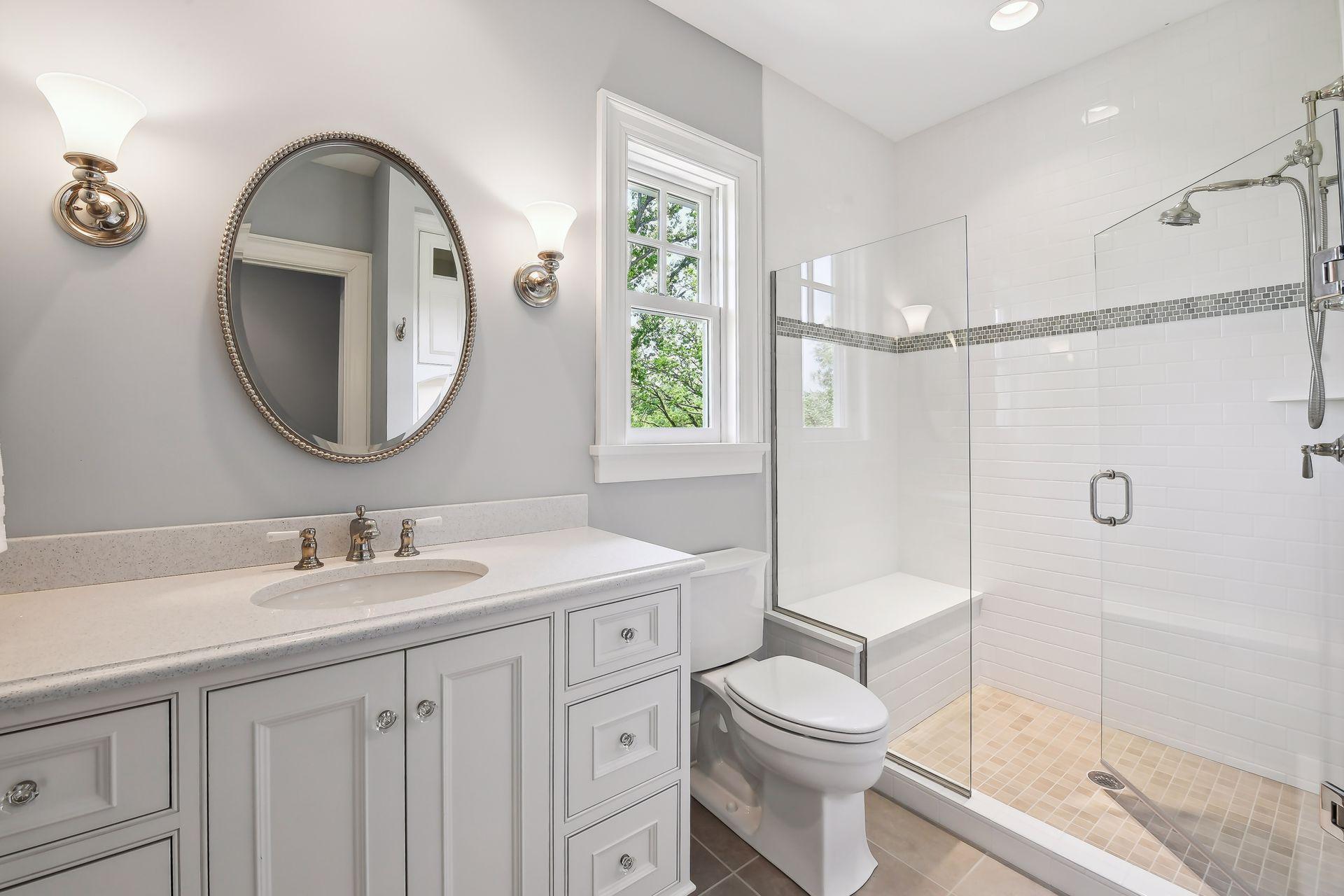 This en suite bath features a spacious, tiled shower and furniture-style vanity.