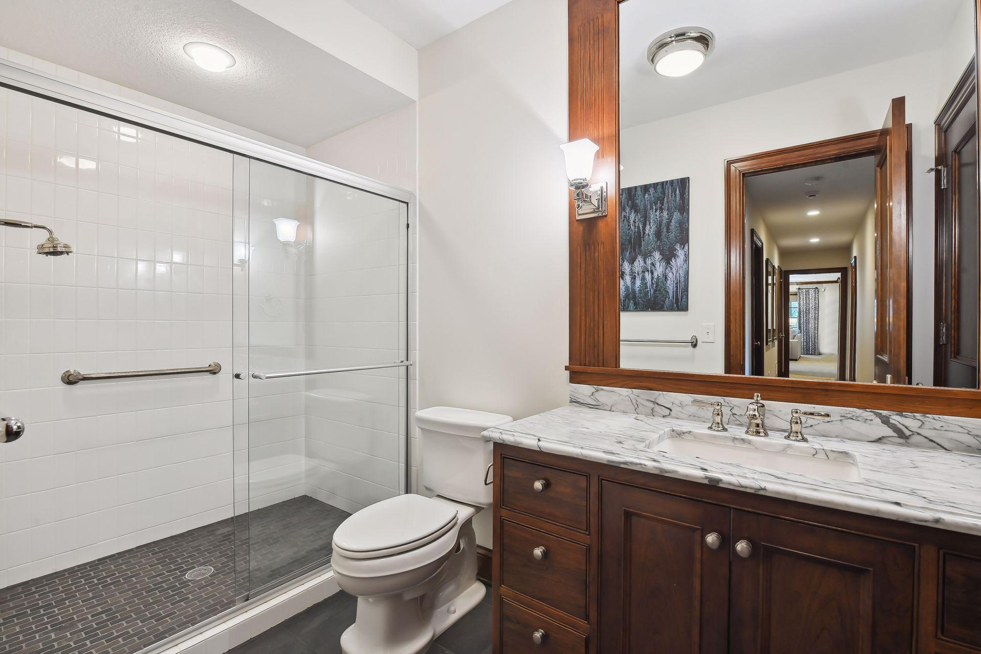 An adjacent 3/4 Bathroom features a tiled shower and custom vanity.