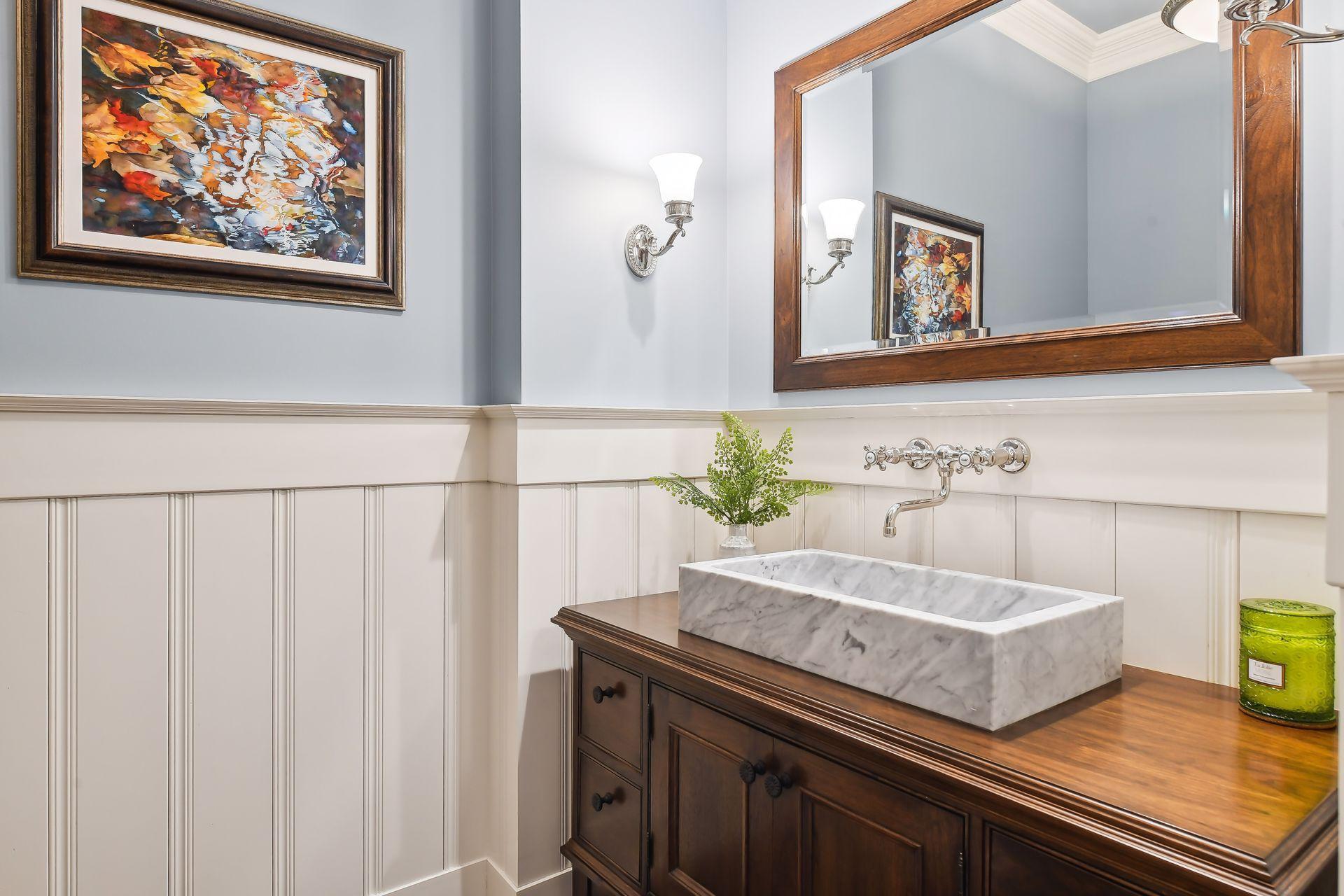 Beautifully finished, the Powder Room offers a cherry vanity with marble sink, enameled crown crown moulding and wainscoting and a free-standing linen cabinet.