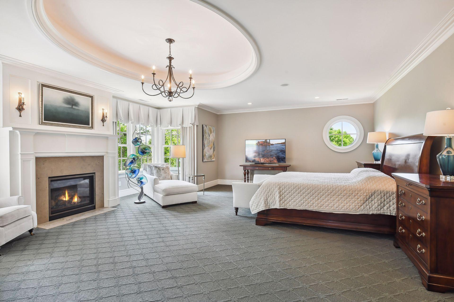 Tucked away behind a set of French doors it the Primary Suite. This tranquil oasis offers a gas fireplace, custom inset oval ceiling with uplighting and room for occasional seating.