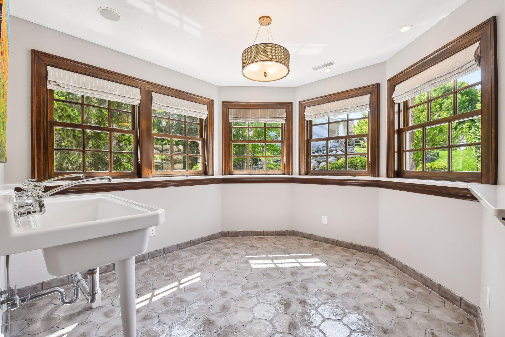 The Conservatory features tiled flooring and a double vintage-style sink. This is a great spot to set up your appetizer buffet for a Superbowl party or a festive Barbeque!