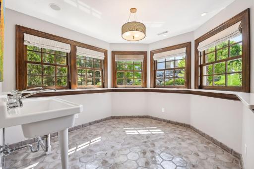 The Conservatory features tiled flooring and a double vintage-style sink. This is a great spot to set up your appetizer buffet for a Superbowl party or a festive Barbeque!