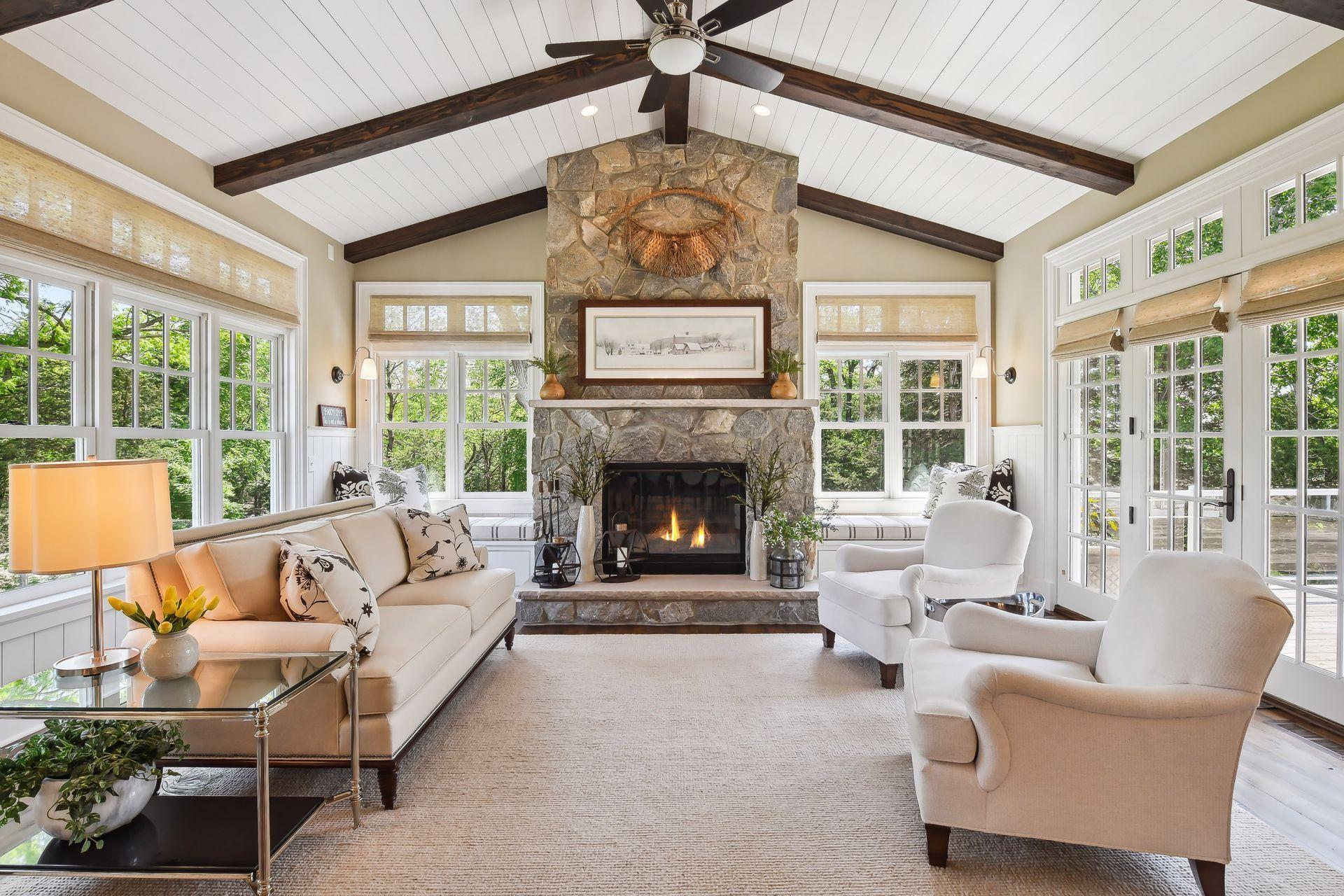 Walls of windows flank the wood-burning fireplace in the inviting Sun Room.