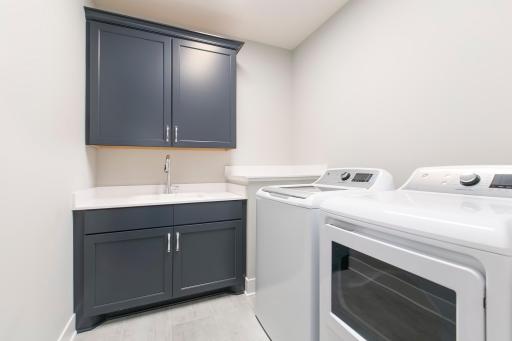 Laundry room with storage space and sink.