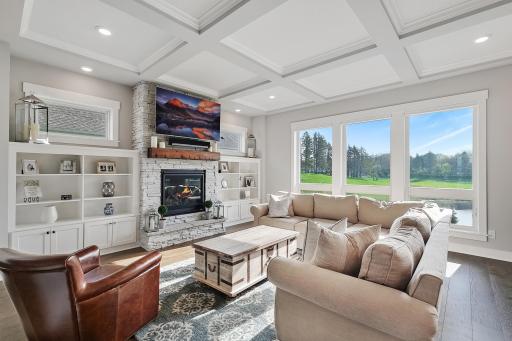 Spacious living room with coffered ceiling detail and enormous window.