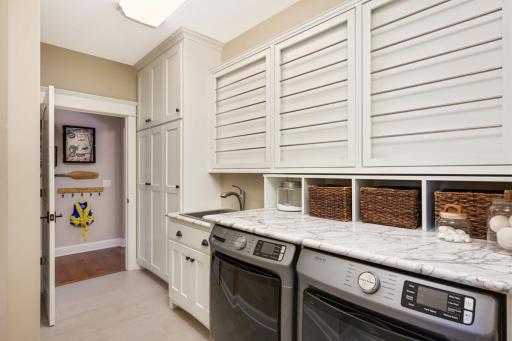 Ceramic plank floor tile in this conveniently located main floor laundry room. New front load washer & dryer. The Formica countertop & cubbies can be removed (not attached). Custom built, framed pull-down drying racks, deep sink, tons of storage!