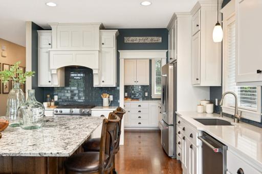 Beautiful quartz countertops on the perimeter with granite on the island. Straight ahead, through the pocket door, is the Sous Chef pantry.