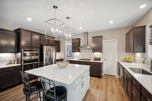 Photo for 6613 Coach House Lane, Corcoran, MN 55340 - Listing #6369342 Designer appointed gourmet kitchen is sure to impress and be a focal point for gatherings. Photo is of model. Color and finish can vary.