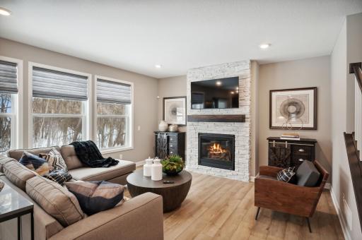 Photo for 6613 Coach House Lane, Corcoran, MN 55340 - Listing #6369342 The spacious family room accented by large windows and 9' ceilings. **The home under construction will have a corner fireplace with mantle high stone surround. Photo is of model home. Color and finish can vary.