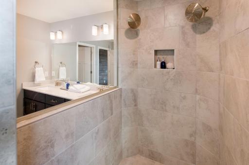 The owner's bath features the spa like Serenity shower with dual rain heads. Photo is of model home. Color and finish can vary.