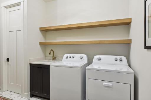 Main floor laundry room with shelving and linen closet.