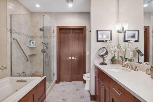 Primary bath with dual sinks, whirlpool tub, separate shower and walk in closet