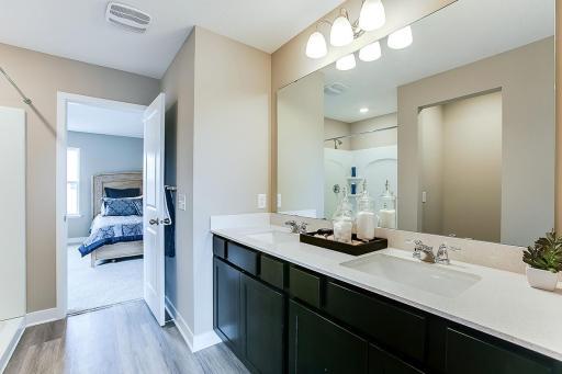 Connected to the primary suite is this bathroom, which includes a double-vanity, stand-in shower and serves as the passage way to the bedrooms oversized walk-in closet!! (Photos of the same floorplan, colors will vary)