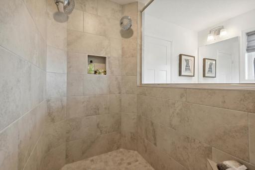 Primary suite walk in tiled shower with dual shower heads! *Please note, photos are not of actual home, but of a similar model. Colors and features will vary in actual home.